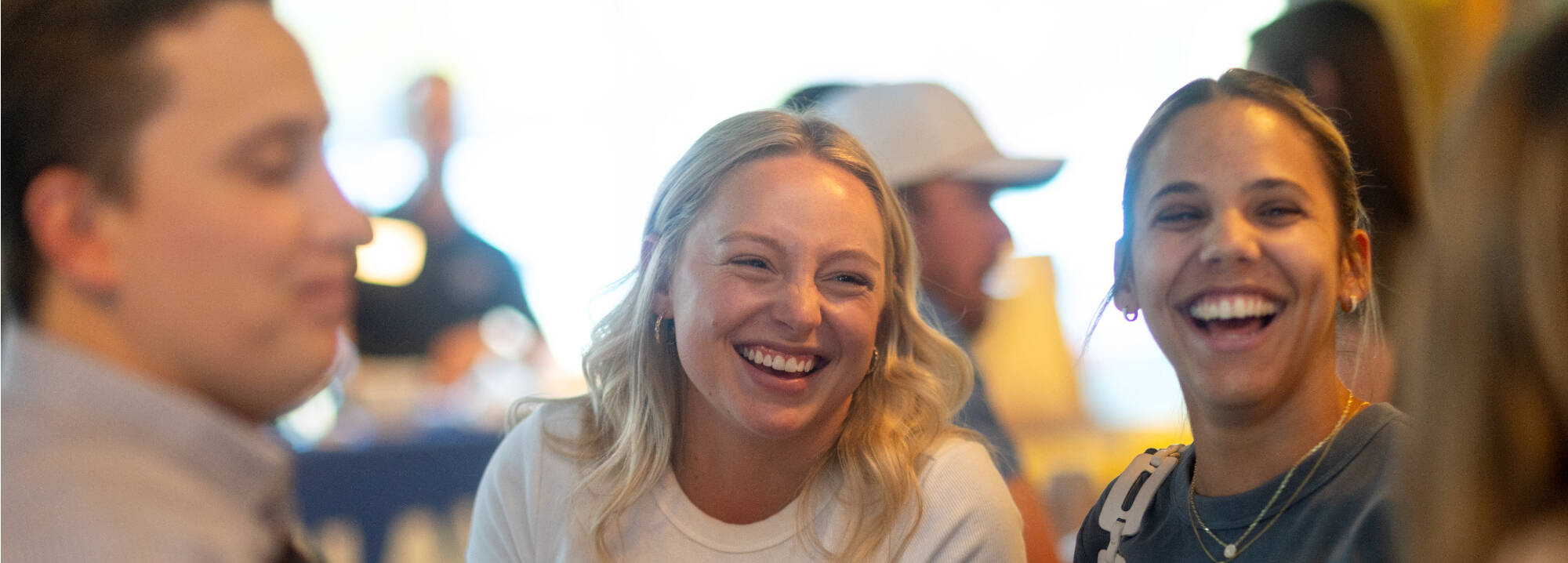 Two women laughing at a social event